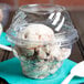 A clear plastic Fabri-Kal sundae cup with a spoon in it.