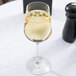 A Stolzle white wine glass filled with white wine on a table.