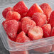 A plastic container of Dole whole frozen strawberries.