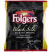 A black Folgers Black Silk ground coffee packet on a counter.