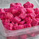 A plastic container of Dole IQF pink Pitaya chunks.