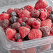 A plastic container of Dole frozen mixed berries.