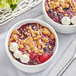 Two bowls of Dole IQF mixed berry dessert with crumble and whipped cream.