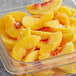 A plastic container of Dole IQF sliced peaches on a counter.