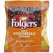 A Folgers Colombian Supreme coffee packet. A white bag of Folgers Colombian coffee beans.