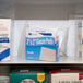 A shelf with two white boxes of Medi-First sterile gauze pads.