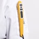 A person in a white lab coat using a yellow Taylor digital pocket probe thermometer.