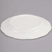 A CAC ivory china plate with a scalloped edge.