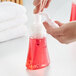 A person's hand using Dial Power Berries Antibacterial Foaming Hand Wash in a foaming soap pump.