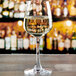 An Anchor Hocking Florentine II wine tasting glass filled with white wine on a table.