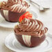 A close up of a Mona Lisa marbled chocolate tulip cup filled with chocolate dessert.