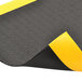 A black and yellow rubber Notrax Pebble Step Sof-Tred mat with a black stripe.
