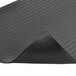 A black rubber Notrax Airug anti-fatigue mat with a corner rolled up.