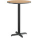 A Lancaster Table & Seating round bar height table with a reversible walnut and oak laminated top on a black base.