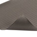 A close-up of a black Notrax anti-fatigue mat with a gray stripe.
