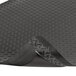 A black rubber Notrax Dura Trax Grande anti-fatigue mat with a corner curled up.