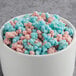 A white bowl filled with pink and blue cotton candy clusters.