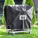A black Backyard Pro vinyl cover on a grill cart in a yard.