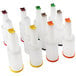 A group of Carlisle white plastic Store N' Pour containers with colorful caps.