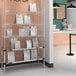 A Metro stainless steel heated shelf with 3 chrome shelves and 2 heated shelves with bags on it.