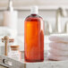 A Boston Round 32 oz. amber plastic bottle with a white disc top lid on a tray with towels.