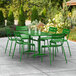 A green Lancaster Table & Seating outdoor table with chairs on a patio.