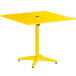 A yellow square Lancaster Table & Seating outdoor table with a metal base.