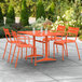 An orange table and chairs on an outdoor patio.