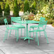 A Lancaster Table & Seating seafoam green table with 4 chairs on a patio.