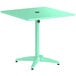 A seafoam green Lancaster Table & Seating outdoor table with a black round top.