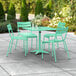 A Lancaster Table & Seating seafoam green table with 4 chairs on an outdoor patio.