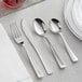 A Visions silver plastic cutlery set with a fork, knife, and spoon on a table.