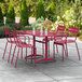 A red outdoor table with chairs on a patio.