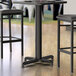 A black Lancaster Table & Seating counter height table base with FLAT Tech Equalizer.