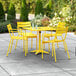 A yellow table and chairs on an outdoor patio with a yellow umbrella.