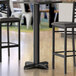 A Lancaster Table & Seating black bar height table base with leveling feet.