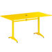 A yellow Lancaster Table & Seating outdoor table with a metal base.