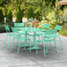 A Lancaster Table & Seating seafoam green table with 6 chairs on a patio.