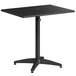 A Lancaster Table & Seating black aluminum table with umbrella hole and arm chairs.