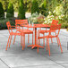 An orange table with four chairs on a patio.