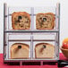 A two tier Cal-Mil bread display case filled with bread and fruit.