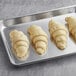 White Toque butter croissants on a baking sheet.