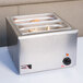 A stainless steel countertop food warmer with a tray of food in a pan.