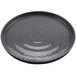 A black GET Roca melamine round plate with ripples on a table.