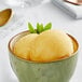 A bowl of Acai Roots passion fruit cream sorbet with a yellow hue.