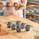A non-stick carbon steel popover pan with six cups, designed for baking popovers.