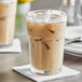 A close-up of an Acopa Memphis beverage glass filled with iced coffee on a white background.