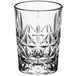 A close up of a clear Acopa shot glass with a star pattern.