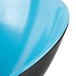 A close up of a blue melamine bowl with a black slanted rim.