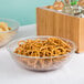A Cambro pebbled serving bowl filled with pretzels and chips.
